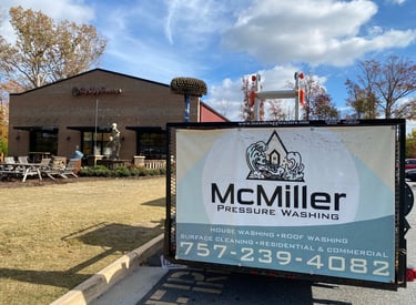 McMiller Pressure Washing trailer parked in front of a commercial brick building for exterior cleaning services.