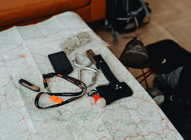 Accesorios para camping incluyendo un mapa, gps, navaja y lampara LED
