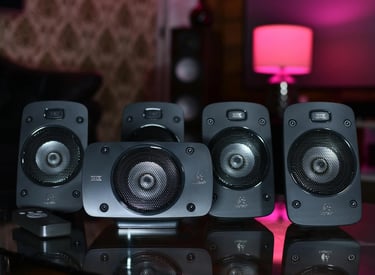 varios subwoofers de color negro sobre una mesa de cristal