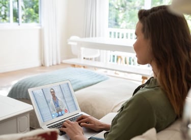 a woman sitting on a couch with a laptop computer