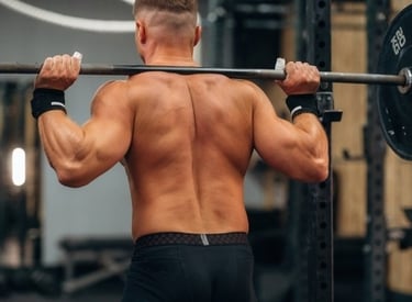 a man with a barbell in his hand on his back