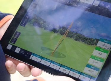 A golf coach in Aberdeen runs a gapping session using a launch monitor to help a player determine distances for each club