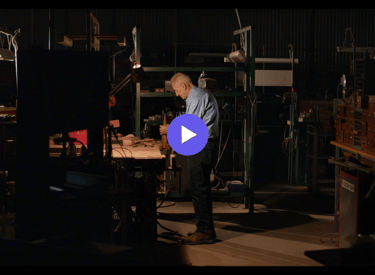an man in a work shop with a blue shirt