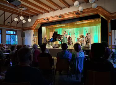 a group of people sitting at a table with a piano