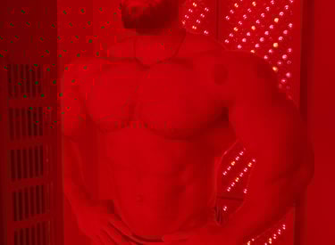 a man with a beard and eye protection on a red light therapy