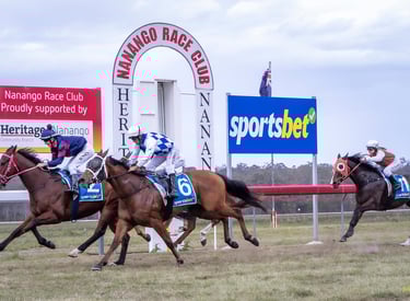 Horses racing past the finish line