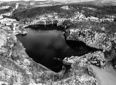 Black & white image of the Rock of Ages granite quarry in Barre, VT during the winter