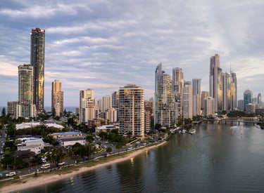 Aerial view of Meriton Suites Surfers Paradise facing the river, with the Gold Coast skyline in the background.