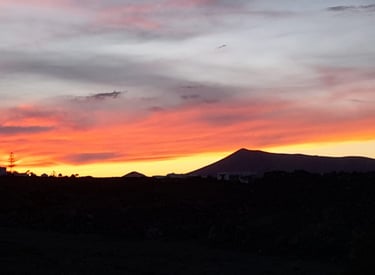 a sunset sky with a mountain in the background