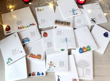 Handmade tear-off memo pads with colorful illustrations, pumpkins, and birds on a wooden table.