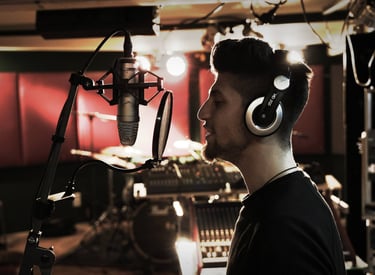 a man in a recording studio with headphones sings