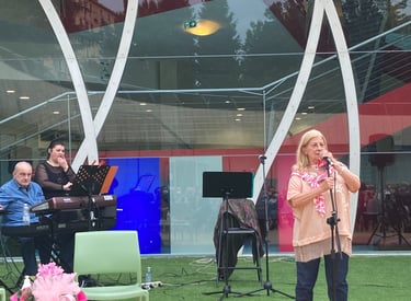 a woman in a pink shirt is standing in front of a microphone and a man