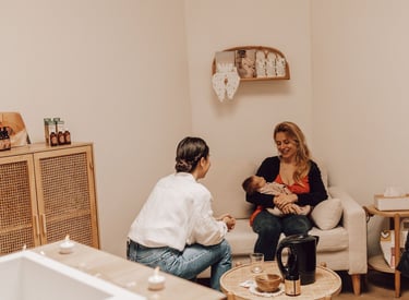 une femme qui se fait aider avec son bébé par une accompagnante périnatale