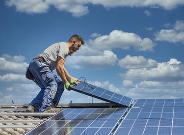 Professional technician installing solar panels on a residential rooftop for renewable energy.