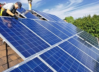 Professional contractor installing solar panels on a residential rooftop for renewable energy.
