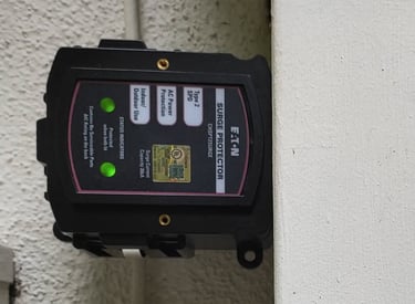 Eaton Type 2 SPD whole home surge protector with green status indicator lights mounted on an exterior wall.