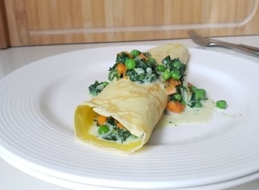 rolled German pancake on white plate with green veggies - copyright Tanja Dietzig