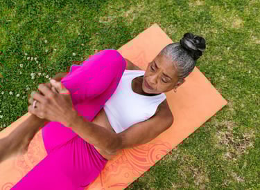 elderly adult female stretching on a yoga mat