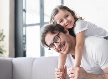 A man and a little girl are smiling and having fun