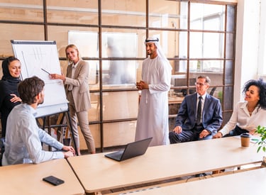 A diverse, cross-cultural team collaborates during a leadership training presentation.