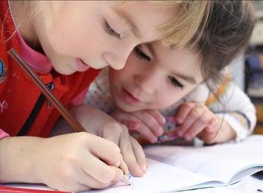 Two young girls working together to complete a workbook