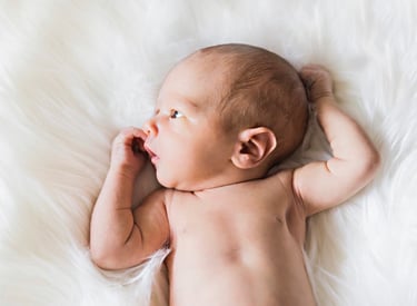 Gorgeous newborn lying awake on bed