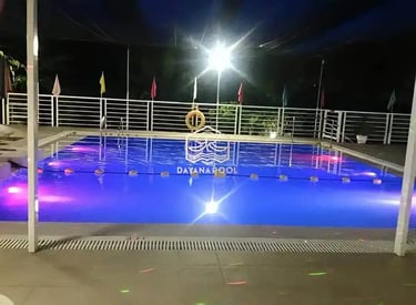 Pemandangan kolam renang yang tenang di malam hari, menciptakan suasana oase di perkotaan.