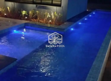 Pemandangan kolam renang yang tenang di malam hari, menciptakan suasana oase di perkotaan.