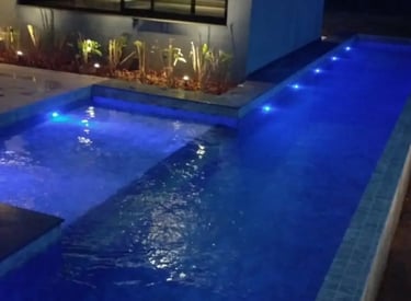 Pemandangan kolam renang yang tenang di malam hari, menciptakan suasana oase di perkotaan.