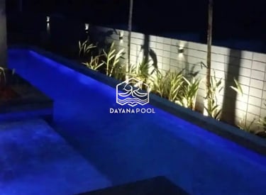 Pemandangan kolam renang yang tenang di malam hari, menciptakan suasana oase di perkotaan.