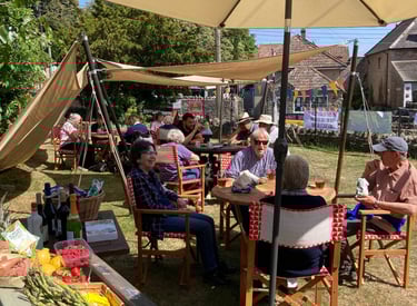 People enjoying sitting in the Westbury-sub-Mendip Community Shop garden in the sunshine