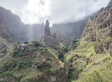 Verdant terraced hills and a towering rock spire in the volcanic mountains of Santo Antao, Cape Verde.