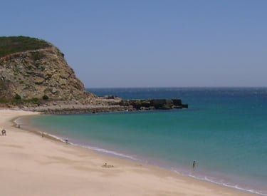 a beach with a sandy beach and a mountain in the background