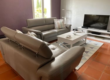 Salon moderne avec divan en cuir et télévisions moderne