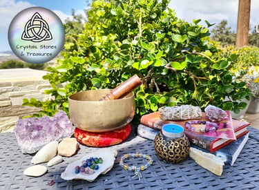 a singing bowl and crystals stones bracelets and Amethyst crystals on a table