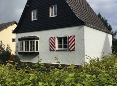 a house with a black and white house with red shutters