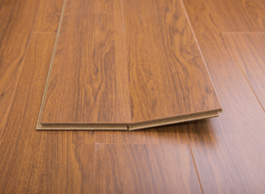 Laminate flooring planks laying on top of installed laminate flooring.