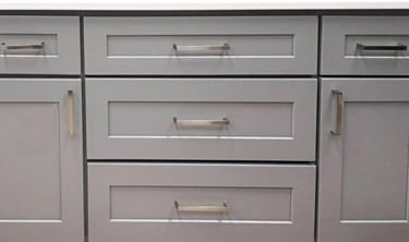 a white euro-style ktichen cabinet with drawers and side doors with silver hangers from ktichenrta