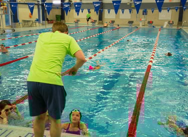 Coach demonstrating swimming technique to swimmers