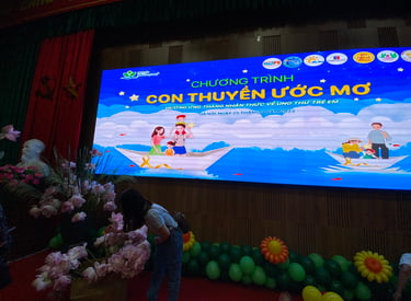 a man and woman standing in front of a large screen