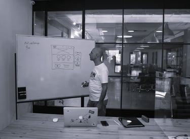 A project lead drawing a system diagram on a whiteboard