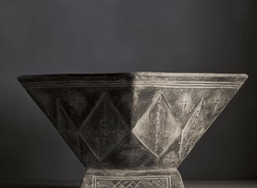 A square-based, flared vessel with geometric carvings and a weathered stone-like surface, exuding a