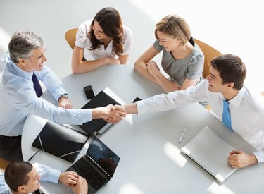 a group of business people shaking hands