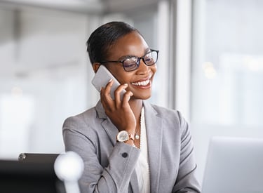 Christian translation services wearing glasses talking on a smartphone in a bright office.