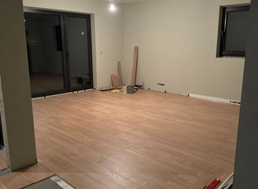 a room with a large wooden floor and a television