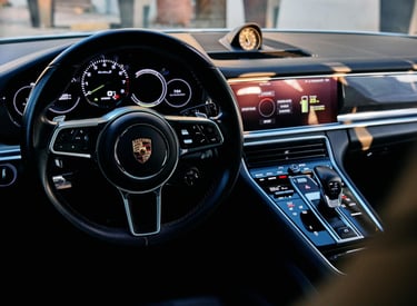 an Enlab Porsche car dashboard with a steering wheel and dashboard controls