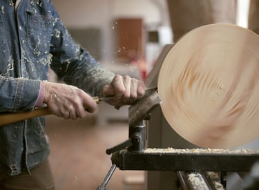a person using a wood lather to make a large wooden bowl