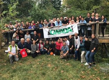 a group of people standing around a banner of GWADA