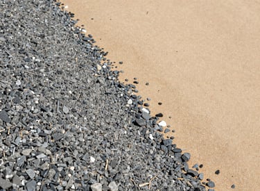 Stacks of gravel ready for delivery at a commercial site.