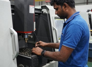 Close-up of a skilled technician operating a CNC machine in a bright engineering workshop.